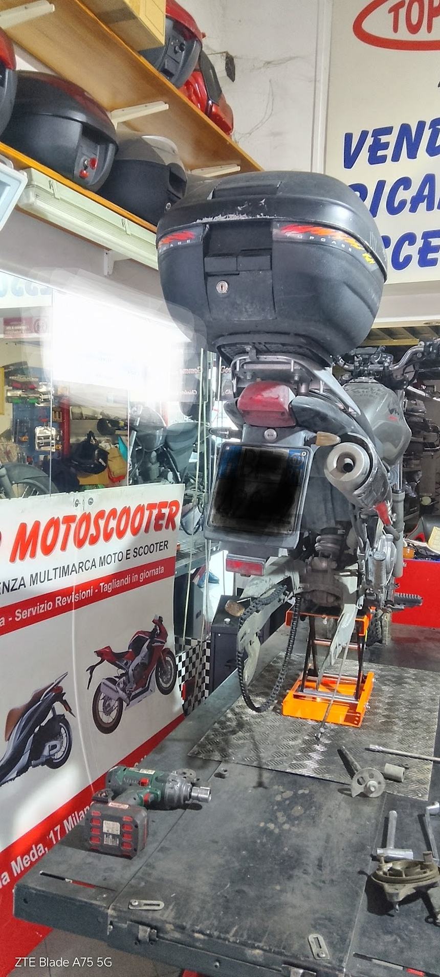 Uno scooter sul ponte dell'officina, con gli attrezzi sul banco